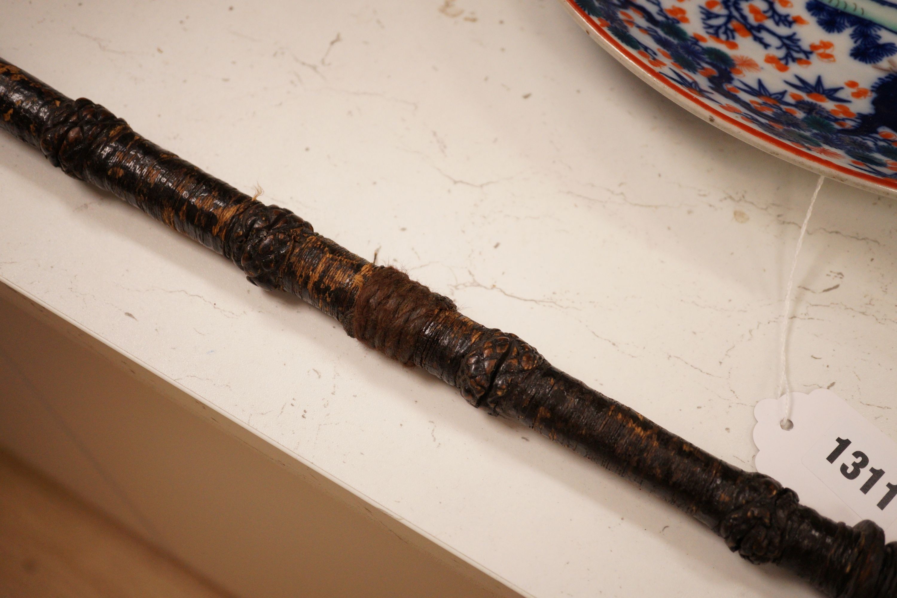 A ceremonial sword stick with removable brush end